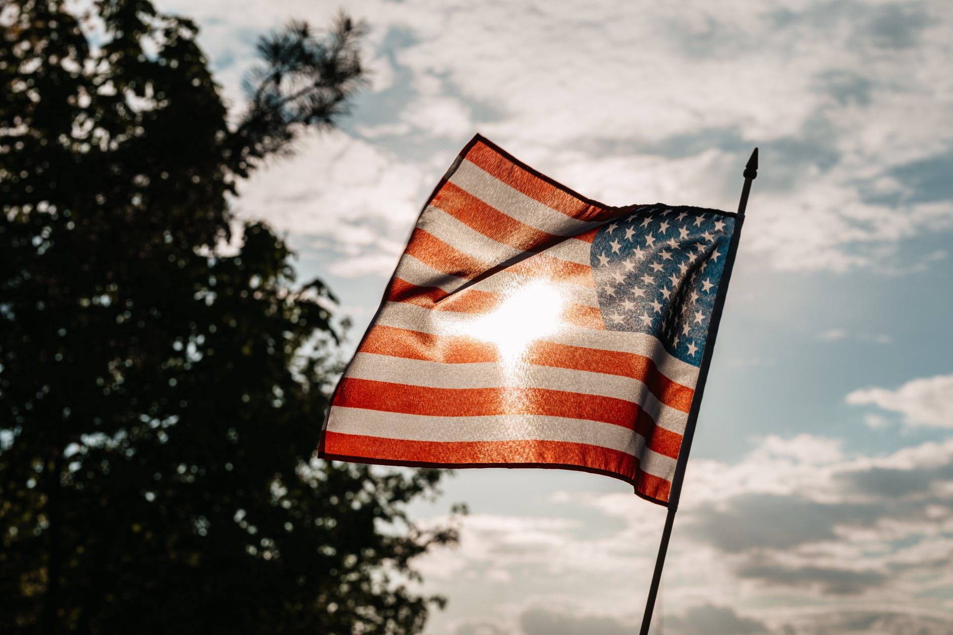 american flag on independence day under cloudy sky